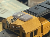 Close-up of a yellow model vehicle with detailed features on a blurred background