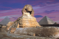 Sphinx and pyramids with a pink and purple sky
