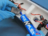 Person applying Fix N Flex adhesive to electronic components with blue gloves.