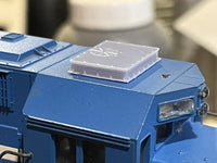 Close-up of a blue model vehicle with a clear plastic component on top.