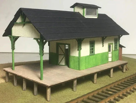 Model of a small train station building with a platform and roof