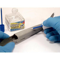 Person applying Plastic Magic Cement to a metal object with gloves on, next to a container of the cement.