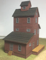 Model of a two-story red brick building with a gray roof on a plain background