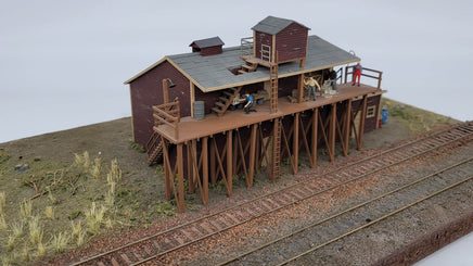 Model train station with people on a track, on a plain background
