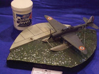 Model airplane on a blue surface with a container labeled 'Making Waves'.