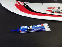 Tube of Fix N Flex on a black surface with a red and white circular object in the background