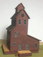 Model of a two-story building with a clock tower on a plain background