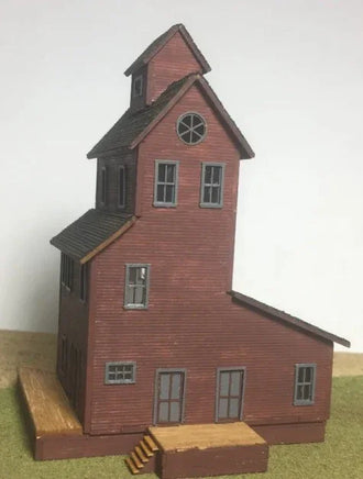 Model of a two-story building with a clock tower on a plain background