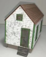 Model of a small wooden house with a brown roof on a white background