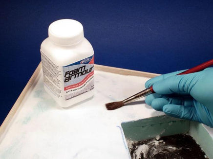Foam Armour product with a brush and gloved hand on a blue background
