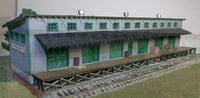 Model train station building on a track with a white background