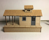 Model of a wooden cabin with a shingled roof on a plain background