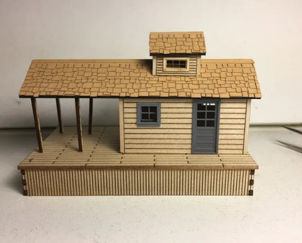 Model of a wooden cabin with a shingled roof on a plain background