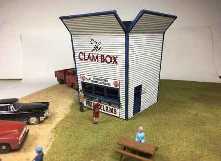 Model of 'The Clam Box' restaurant with vintage cars and people around it.