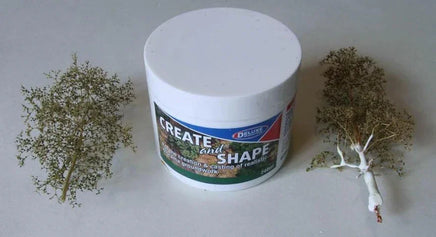 Container of modeling clay with two small sculptures on a plain background