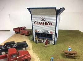 Model of a clam shack with vintage trucks and people around it.