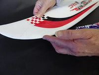 Person holding a white object with red and black design, possibly a product or tool.