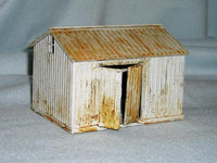 Model of a rustic shed with corrugated metal siding on a gray background