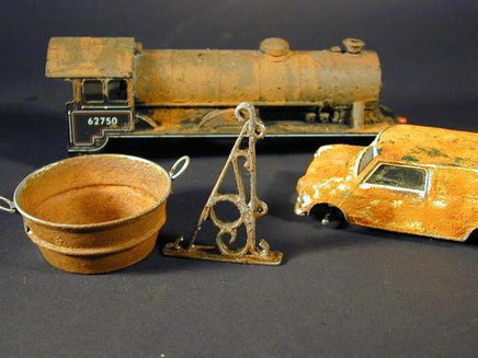 Collection of vintage toy models including a train, car, and other items on a dark background