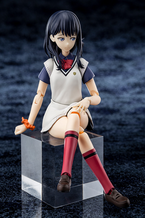 Figurine of a character in a school uniform sitting on a black cube with a dark textured background
