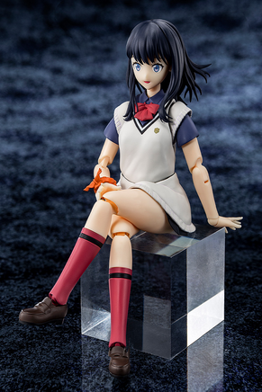 Figure of a character in a school uniform sitting on a block against a dark textured background